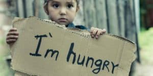 child holding a sign that says I am hungry