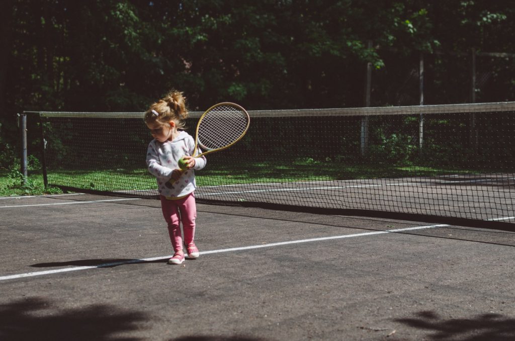 A young girl plays tennis